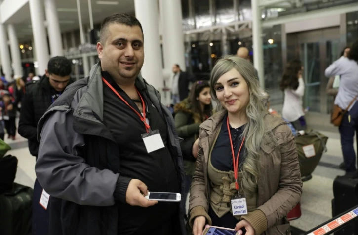 Des réfugiés syriens, qui ont obtenu des visas humanitaires du gouvernement italien, attendent dans la salle des départs de l'aéroport international de Beyrouth le 1er mars 2017 avant leur vol pour Rome