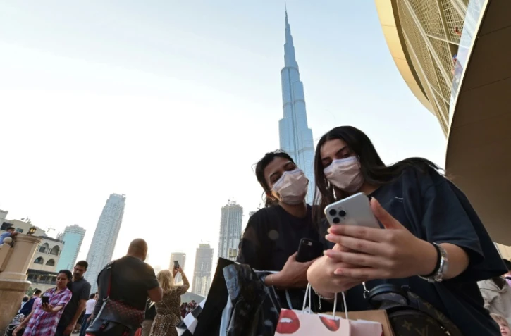 Des femmes avec des masques de protection devant la tour Burj Khalifa, Ă DubaĂŻ, aux Emirats, le 8 mars 2020