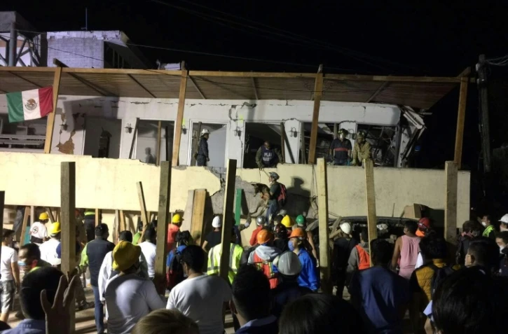 Des équipes de secours recherchent des personnes dans les décombres d'un immeuble qui s'est effondré après un séisme, le 19 septembre 2017 à Mexico