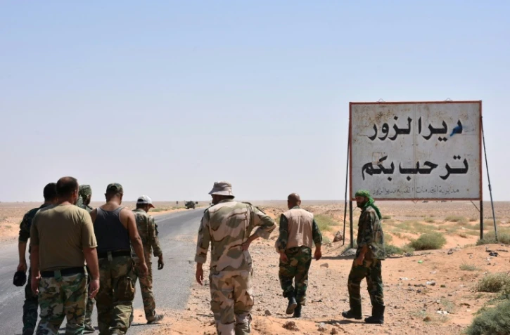 Des soldats des forces armées syriennes près d'un panneau "Bienvenue à Deir Ezzor", le 3 septembre 2017