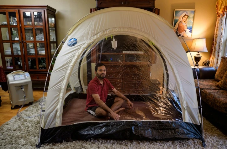 L'alpiniste américain Akash Neggi est assis dans sa tente hypoxique, à son domicile, le 15 avril 2021 à Parlin, aux Etats-Unis