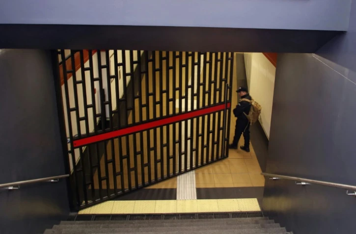 Un agent de sécurité ferme la porte de la station de métro Recreo à Quito après une panne d'électricité le 19 juin 2024