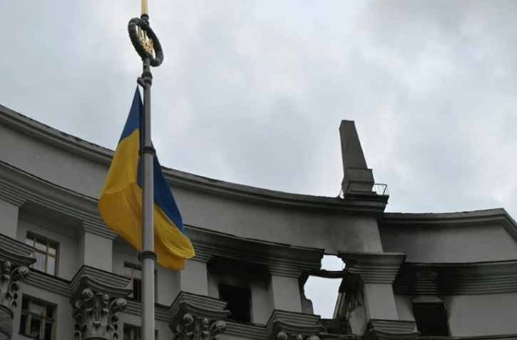 Un drapeau ukrainien flotte devant le bâtiment du gouvernement ukrainien endommagé la veille lors d'une frappe aérienne massive russe, le 8 septembre 2025 à Kiev