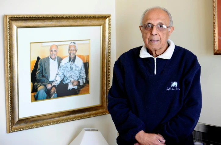 Le vétéran de la lutte anti-apartheid Ahmed Kathrada pose à côté d'une photo de lui avec Nelson Mandela, le 16 juillet 2012 chez lui à Johannesburg, en Afrique du Sud