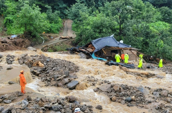 Des secouristes recherchent des survivants dans une maison détruite par les inondations après de fortes pluies à Yecheon, en Corée du Sud, le 15 juillet 2023