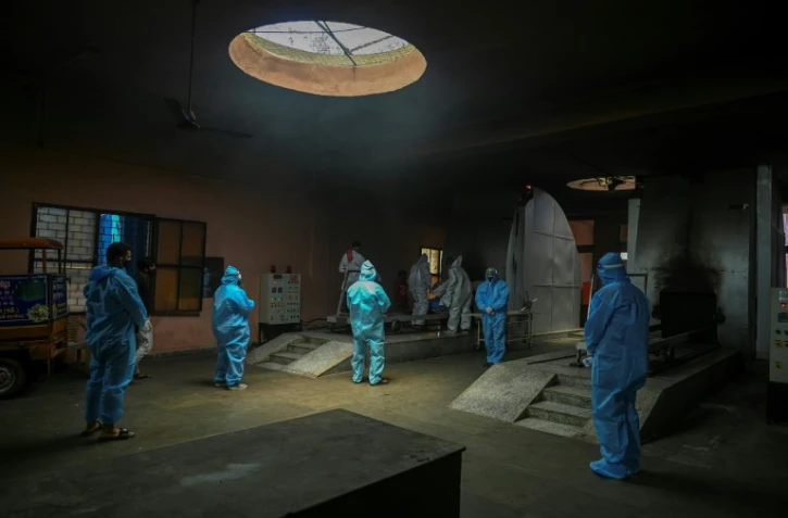 Rites funéraires lors de la crémation d'une victime du Covid-19 dans un crématorium de New Delhi, le 21 mai 2021