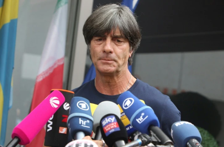 Le sélectionneur allemand Joachim Löw accueilli par les médias lors de son arrivée à Francfort, après la défaite de son équipe en Russie lors des 8es de finale du Mondial, le 28 juin 2018