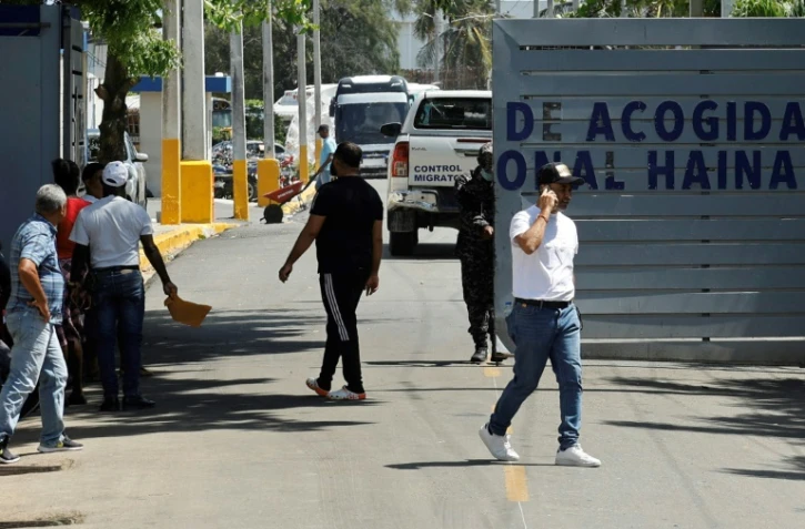 Des personnes attendent devant l'entrée du centre de détention migratoire de Haina, à Saint-Domingue, le 21 avril 2025 en République domincaine