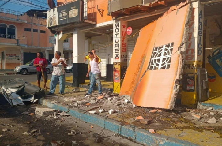 Des habitants devant un magasin endommagé après un tremblement de terre qui a frappé la ville d'Esmeraldas, en Équateur, le 25 avril 2025