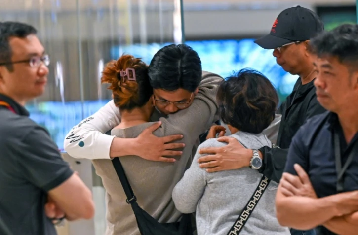 Les passagers du vol SQ321 de Singapore Airlines entre Londres et Singapour, qui a fait un atterrissage d'urgence à Bangkok, retrouvent les membres de leur famille à leur arrivée à l'aéroport de Changi de Singapour, le 22 mai 2024