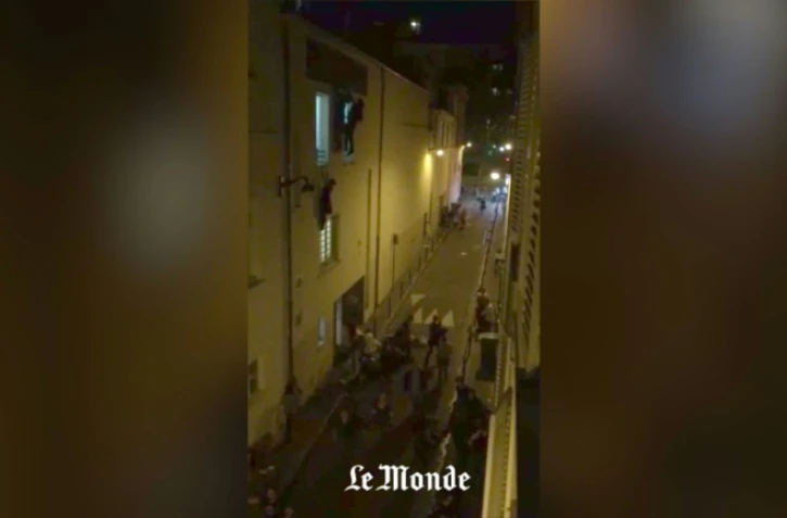 Image extraite d'une vidéo tournée sur un smartphone par un journaliste du Monde montrant des otages du Bataclan suspendus à une fenêtre de la salle de concert ou fuyant dans la rue pendant l'attaque, le 13 novembre 2015 à Paris
