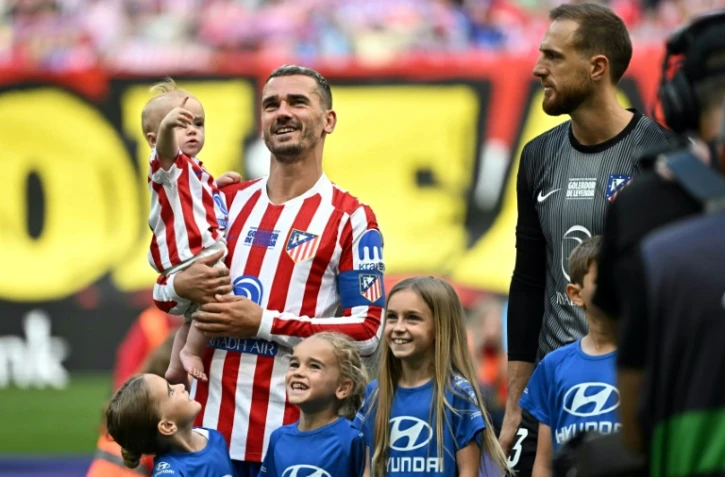 L'attaquant français de l'Atlético Madrid Antoine Griezmann porte sa fille Shai avant le début du match de Liga contre Gérone, le 17 mai 2026 au Metroplitano
