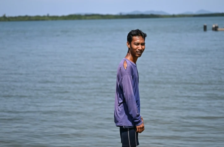 Pirun Kla-Talay, qui a perdu ses parents dans le tsunami de 2004, debout sur une jetée dans le district de Bang Wa, dans la province de Phang Nga, le 19 novembre 2024 en Thaïlande