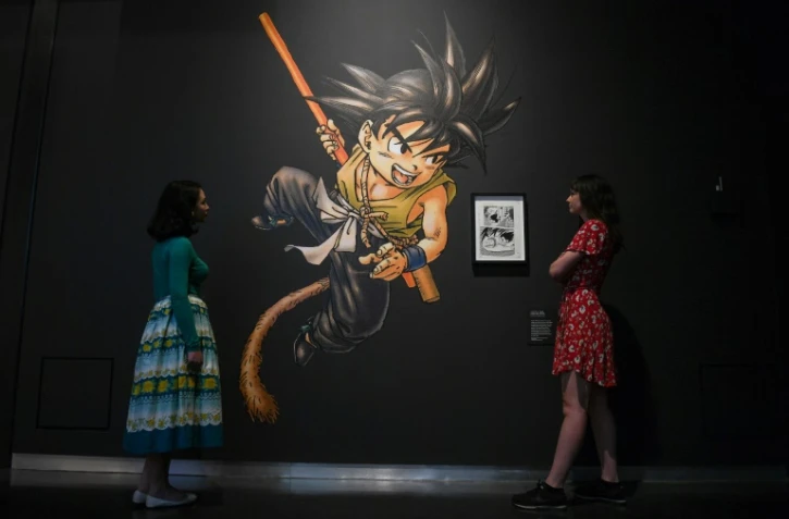 Des employés d'un musée posent à coté d'une œuvre d'art de la série de mangas Dragon Ball, de Toriyama Akira, lors d'une avant-première pour l'exposition "Manga" au British Museum à Londres, le 22 mai 2019