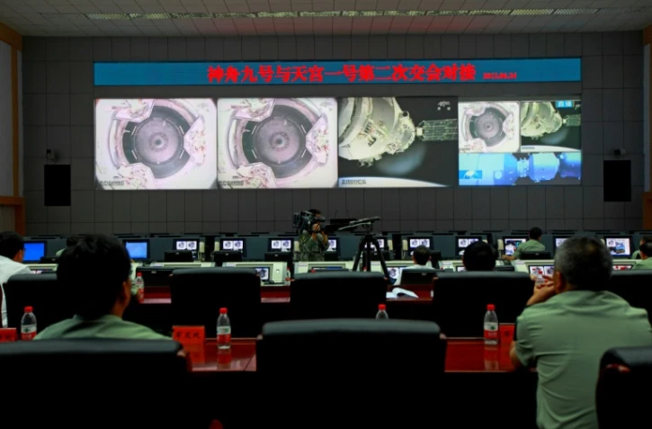 Des scientifiques chinois au Centre spatial de Jiuquan surveillent le vaisseau spatial Shenzhou-9 alors qu'il se prépare à relier le module Tiangong-1, le 24 juin 2012