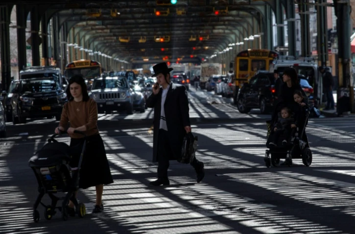 Des passants dans le quartier de Borough Park, à Brooklyn, au début de la semaine de la Pâque juive, le 26 mars 2021