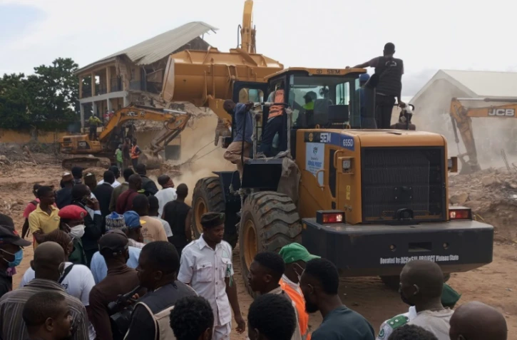 Des secouristes utilisent des pelleteuses sur le site de l'école qui s'est effondrée à Jos, au Nigeria, le 12 juillet 2024