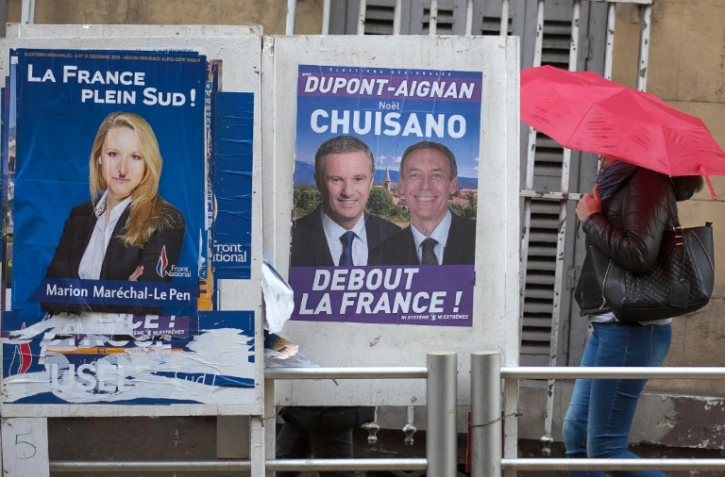 Une femme passe devant un panneau électoral à Marseille, le 7 décembre 2015