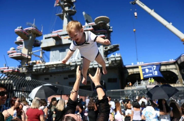 Des familles se réjouissent à l'arrivée du porte-avions américains USS Abraham Lincoln sur la base navale de San Diego, en Californie, le 8 octobre 2026