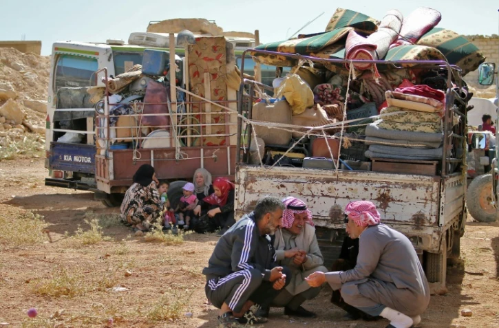 Des réfugiés syriens attendent le départ du convoi qui les ramènera chez eux, dans la localité d'Arsal, dans l'est du Liban, le 28 juin 2018