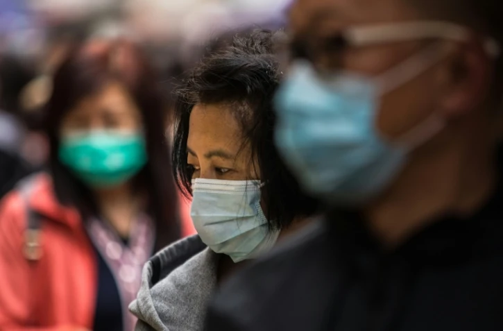 Des passants avec des masques de protection dans les rues de Hong Kong, le 9 février 2020