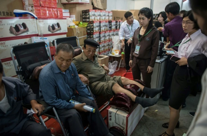 Des Nord-Coréens testent un masseur lors de 13e Foire internationale à Pyongyang, le 25 septembre 2017