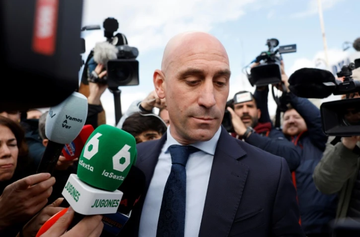 L'ancien président de la fédération espagnole de football, Luis Rubiales (c), entouré par les médias, quitte le tribunal de San Fernando de Henares, à l'est de Madrid, le 11 février 2025