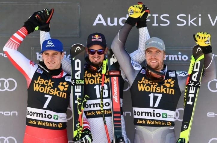 L'Italien Dominik Paris (c) pose sur le podium après avoir remporté le super-G de Bormio, le 29 décembre 2018