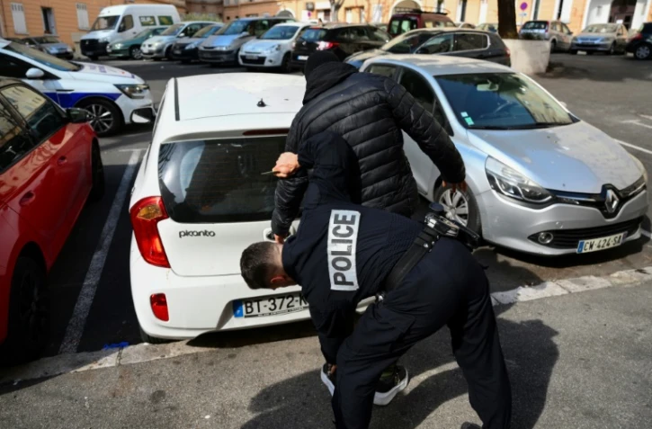Un policier d'une unité spécialisée de terrain fouille un dealer présumé dans un quartier nord de Marseille, le 31 mars 2023