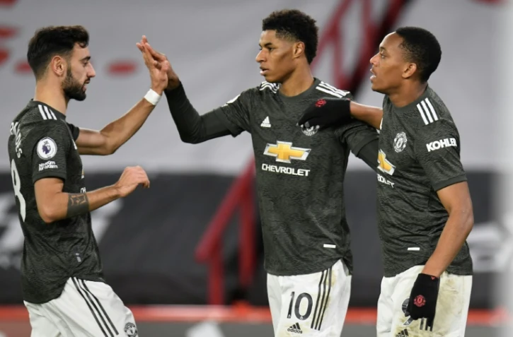 Les attaquants de Manchester United, l'Anglais Marcus Rashford (c) et le Français Anthony Martial, tous les deux buteurs, sont félicités par le milieu de terrain portugais Bruno Fernandes, lors de leur match de Premier League, le 17 décembre 2020 à Sheffield