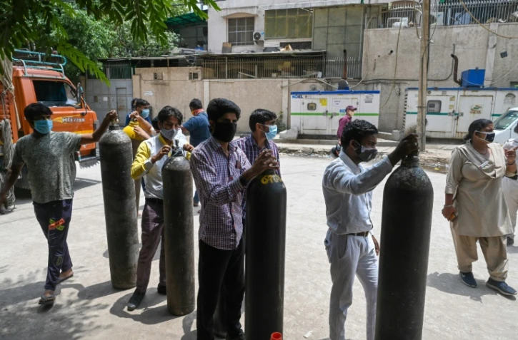 Des gens attendent pour remplir des bouteilles d'oxygène à New Delhi le 12 mai 2021