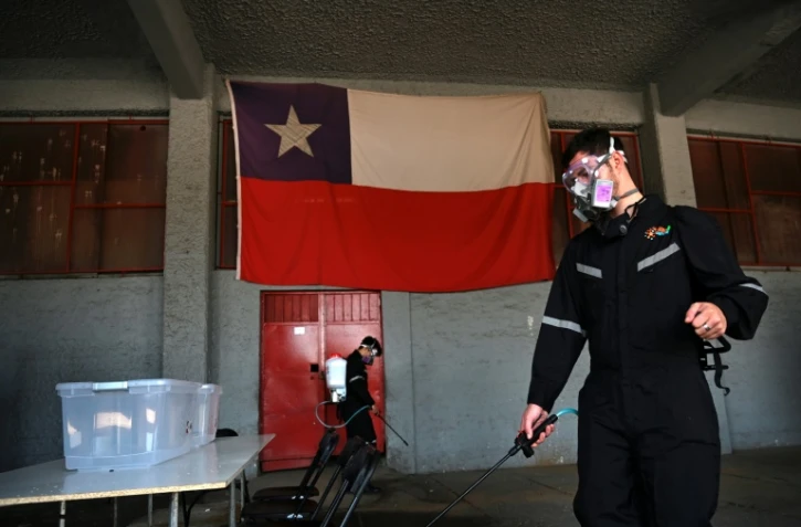 Désinfection d'un bureau de vote avant le référendum sur la Constitution, à Santiago du Chili, le 24 octobre 2020
