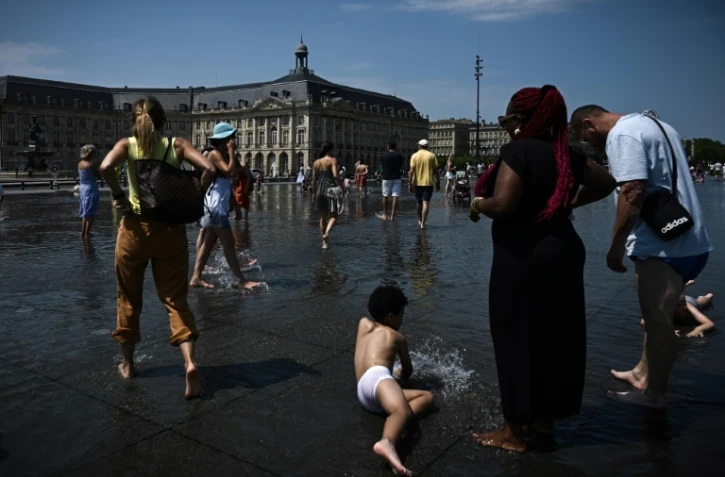 Le public se rafraîchit au "Miroir d'Eau" à Bordeaux, dans le sud-ouest de la France, le 28 juillet 2024, alors qu'une vague de chaleur pèse s'installe sur le sud du pays