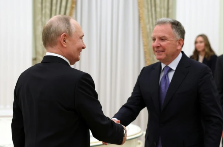 Une photo distribuée par l'agence d'Etat russe Spoutnik montre le président Vladimir Poutine et l'émissaire américain Steve Witkoff se serrant la main lors d'une réunion au Kremlin à Moscou, le 22 janvier 2026