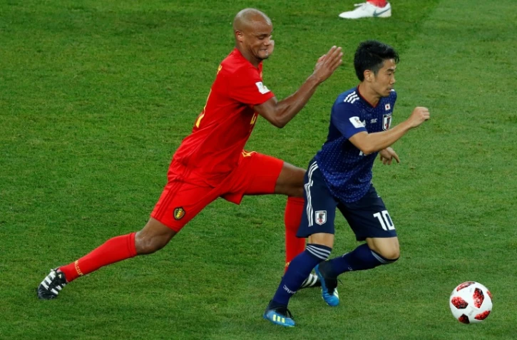 Le défenseur belge Vincent Kompany (g) et le milieu japonais Shinji Kagawa lors des 8e de finale du Mondial le 2 juillet 2018