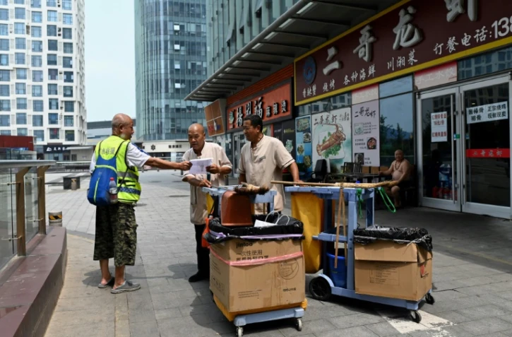 Des volontaires à la recherche de Chen Shaohua, un malade d'Alzheimer ayant disparu, près du centre commercial où il a été vu pour la dernière fois, le 19 juillet 2021 à Pékin