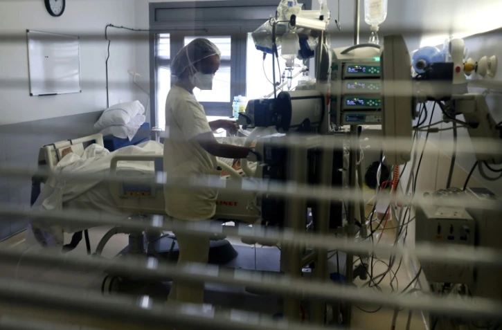 Un soignant s'occupe d'un patient atteint du Covid-19 dans le service de réanimation du CHU de Saint-Pierre, à La Réunion, dans l'océan Indien, le 30 juillet 2021