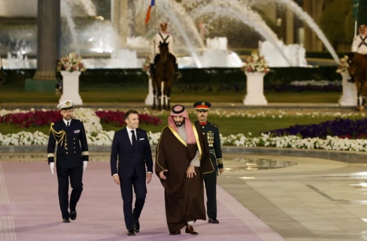 Le président français Emmanuel Macron (G) marche à côté du prince héritier d'Arabie saoudite Mohammed ben Salmane à Riyad, le 2 décembre 2024