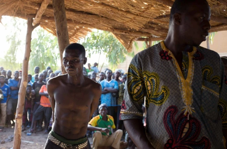 Un homme soupçonné de vol attaché à un poteau lors d'un "procès" expéditif conduit par des groupes d'autodéfense, le 19 mars 2016 à Kokologho près de Ouagadougou 