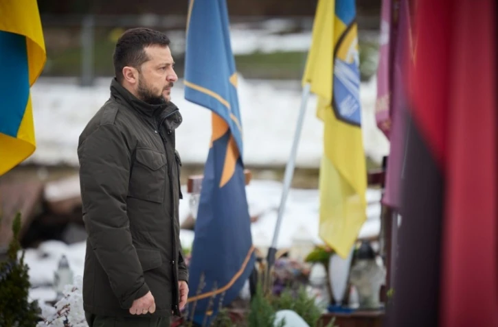 Le président ukrainien Volodymyr Zelensky se recueille devant les tombes de soldats ukrainiens au cimetière Lychakiv, le 15 décembre 2023 à Lviv