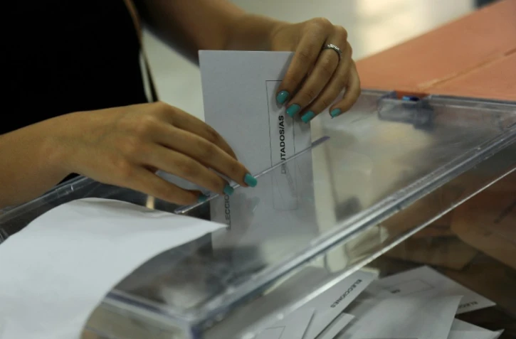 Une femme met son bulletin dans l'urne lors des élections législatives en Espagne, le 26 juin 2016 