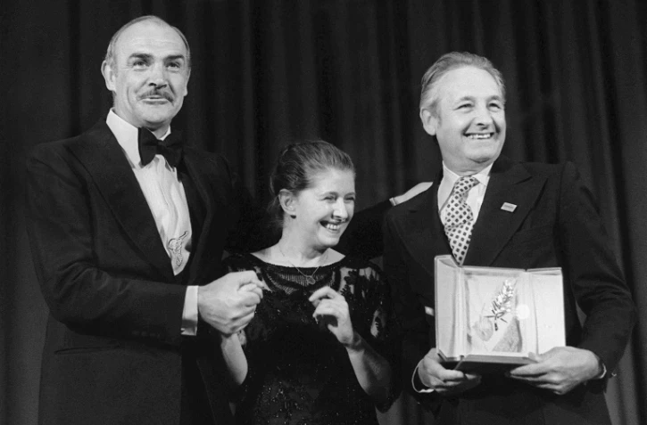 Le cinéaste polonais Andrzej Wajda (d) avec sa palme d'or remise à Cannes le 27 mai 1981, sur scène aux cotés de l'acteur Sean Conneray (g) et de femme Krystyna Zachwatowicz