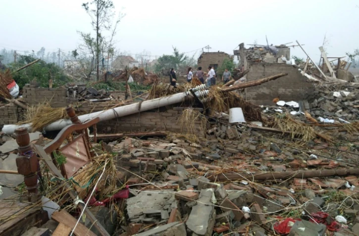 Des habitants de Yancheng, dans la province de Jiangsu à l'est de la Chine marchent dans les ruines des maisons détruites par des pluies torrentielles, de la grêle et des tornades, le 23 juin 2016