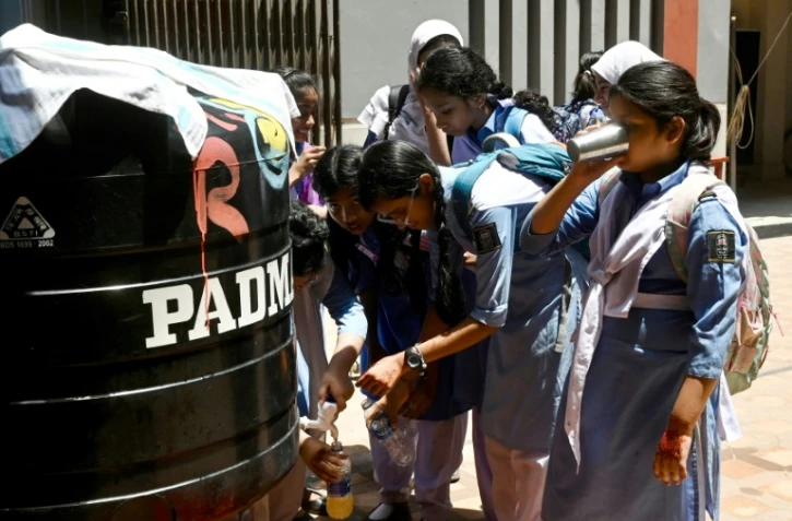Des élèves remplissent leurs bouteilles lors d'une chaude journée dans une école de Dhaka, le 28 avril 2024