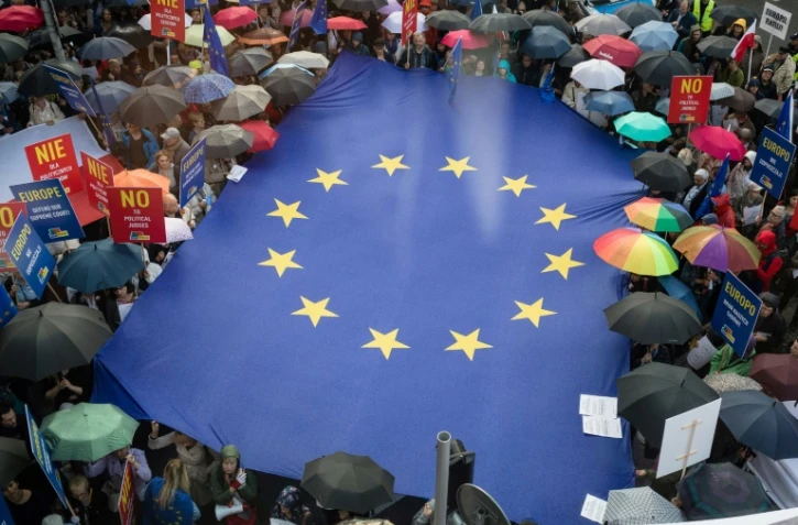 Des manifestants déploient un drapeau européen devant la réprésentation de la Commission européenne, le 26 juin 2018 à Varsovie, pour dénoncer la réforme de la Cour suprême