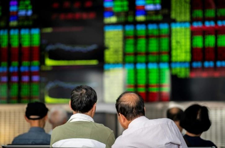 Des investisseurs surveillent le cours des actions à Shangai, en Chine, le 25 septembre 2018