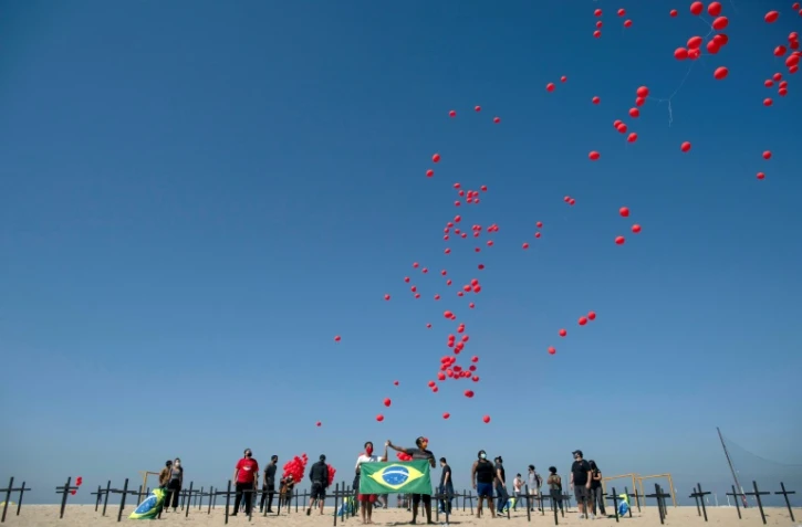 Lâcher de ballons sur la plage de Copacabana de Rio en hommage aux plus de 100.000 morts du Covid-19 au Brésil, le 8 août 2020
