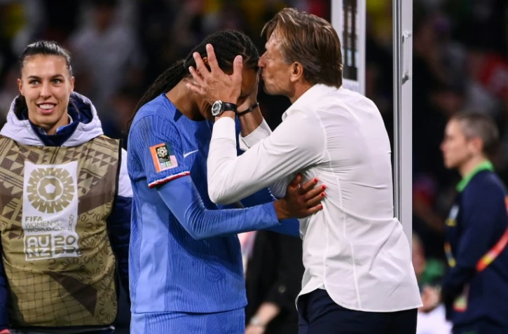 Le sélectionneur français Hervé Renard (d.) embrasse sur le front la défenseuse française Wendie Renard (g.) après la fin du match du groupe F de la Coupe du monde féminine entre la France et le Brésil, à Brisbane le 29 juillet 2023