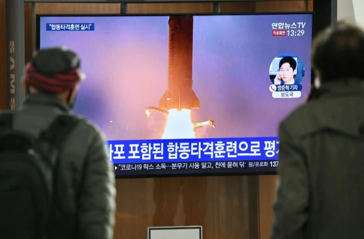 Des personnes regardent les images d'un tir de missiles par la Corée du nord, le 9 mars 2020 dans une gare de Séoul, en Corée du Sud