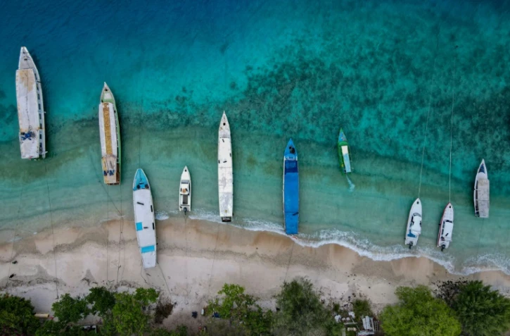 Des bateaux à l'ancre le long d'une plage désertée par les touristes, sur l'île indonésienne de Gili Trawangan le 22 novembre 2021